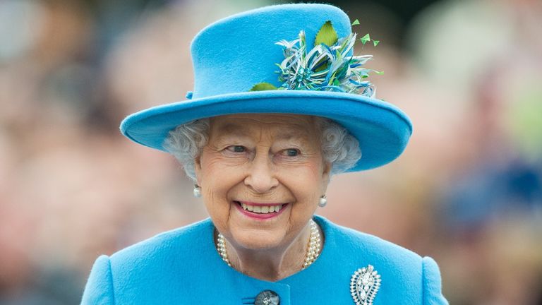 queen smiling in blue hat