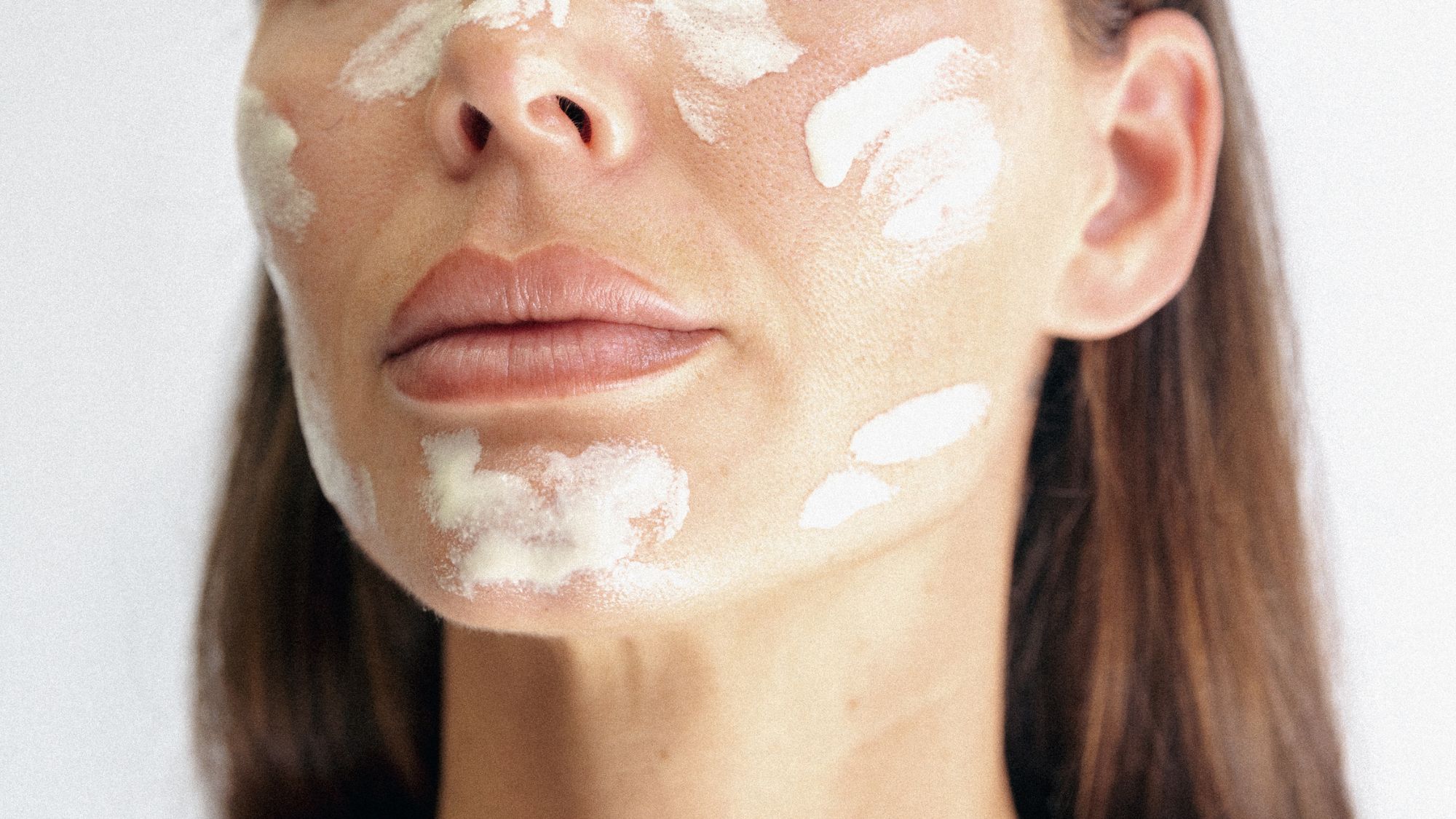 An image of a woman with cream on her skin.