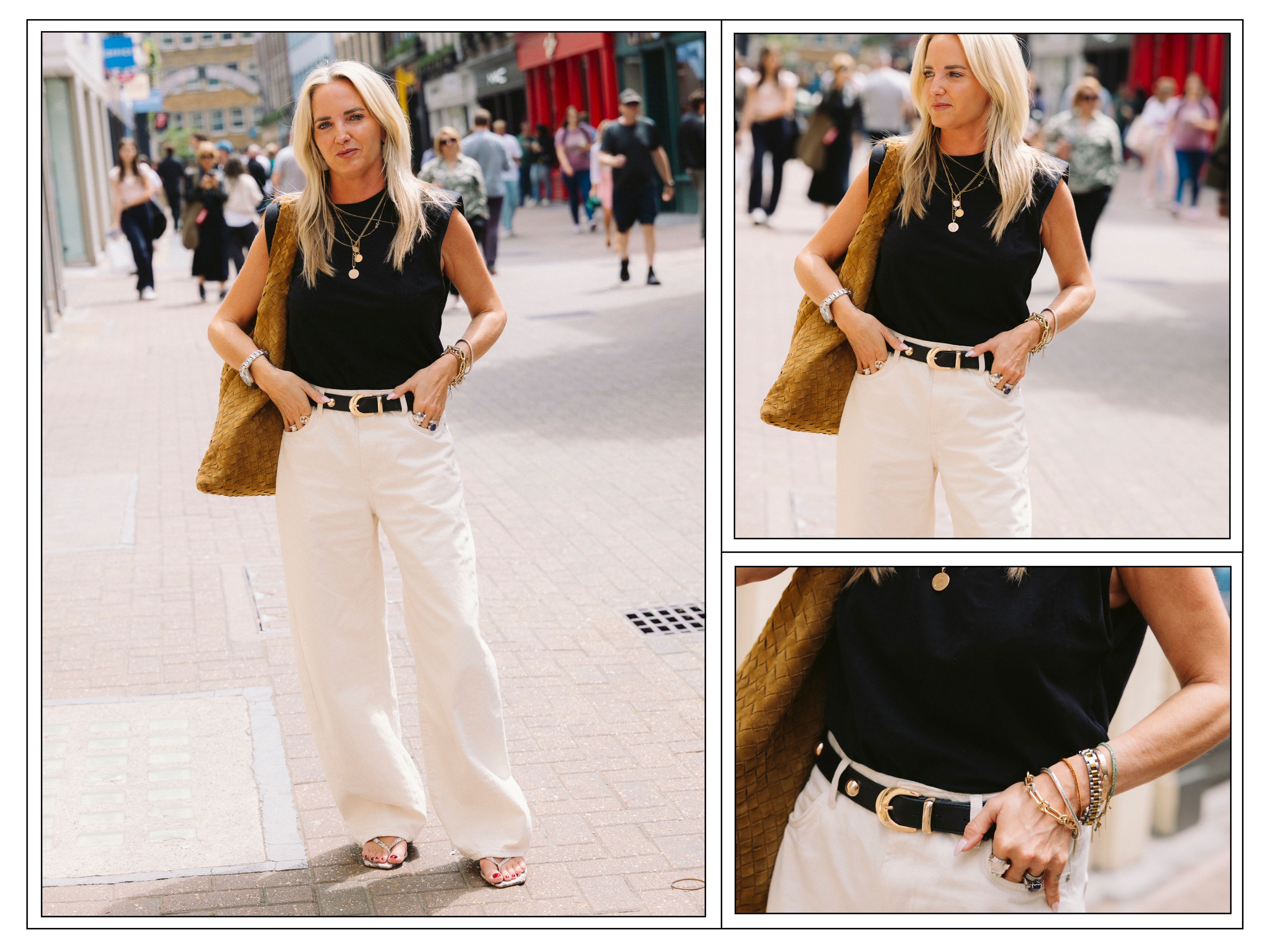 A woman wears cream jeans and a black top with a studded belt in London
