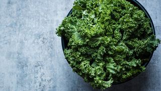 Fresh kale in bowl on slate worksurface