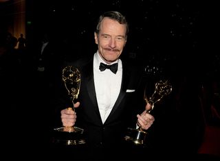 Bryan Cranston holding two Emmys