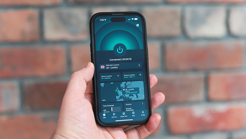 Hand holding an iPhone with the ExpressVPN app open on its home page and in dark mode 