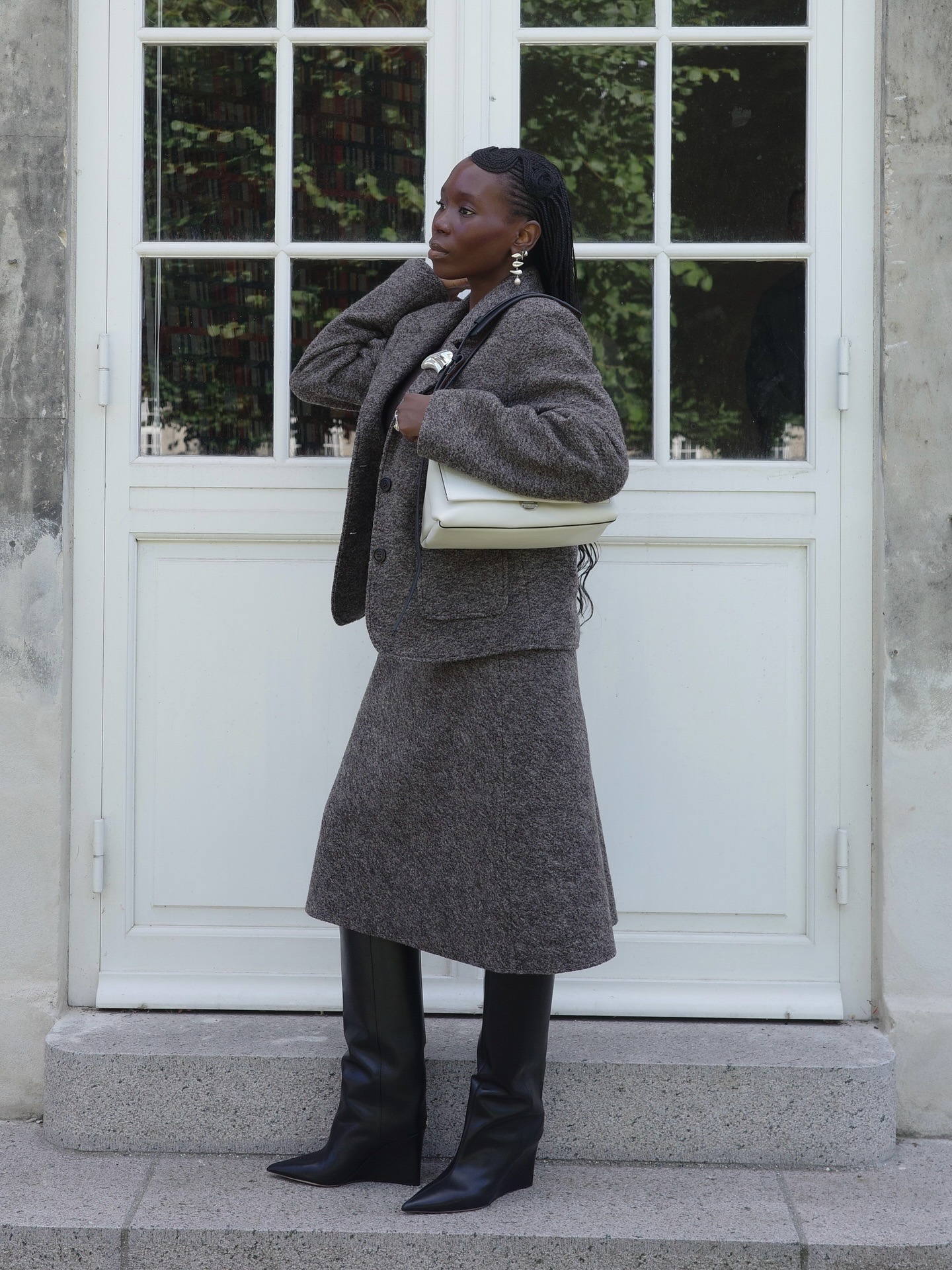 Influencer @daniellejinadu wears black wedge boots with a grey knitted two-piece.