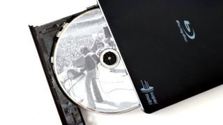 An LG USB Blu-ray drive open showing a Fleetwood Mac CD inside