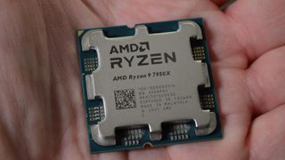 An AMD Ryzen 9 7950X in the palm of a man's hand