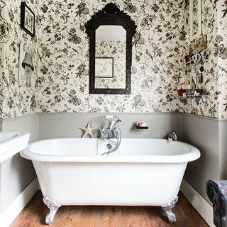 bathroom with white bath tub wooden flooring and pillemont toile wallpaper