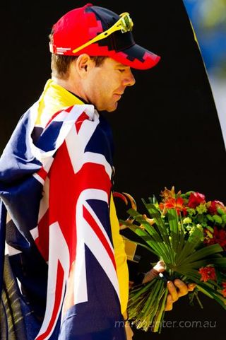 Cadel Evans on the podium in Paris drapped in the Australian flag.