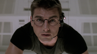 Tom Cruise looking at a computer while being suspended by a wire in Mission: Impossible