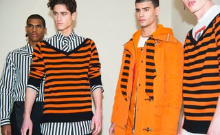 Models posing for a camera, wearing striped orange/black/white clothing.