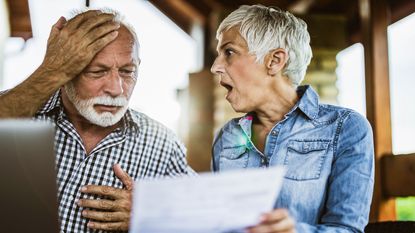 picture of senior couple shocked by what they see on a piece of paper