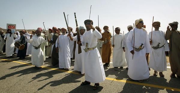 Omani spectators await the peloton to pass by.