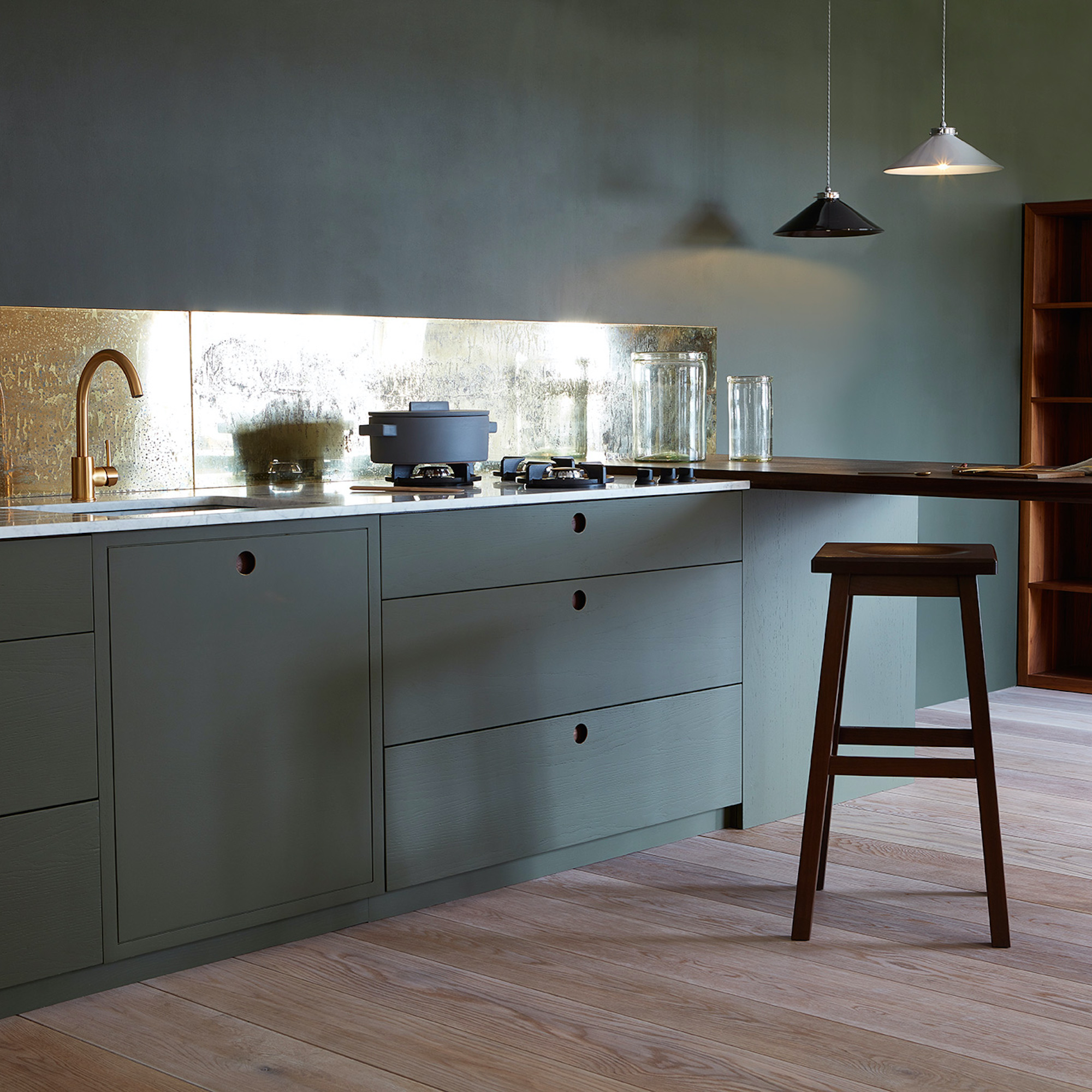 kitchen with dark cabinets and brass splashback