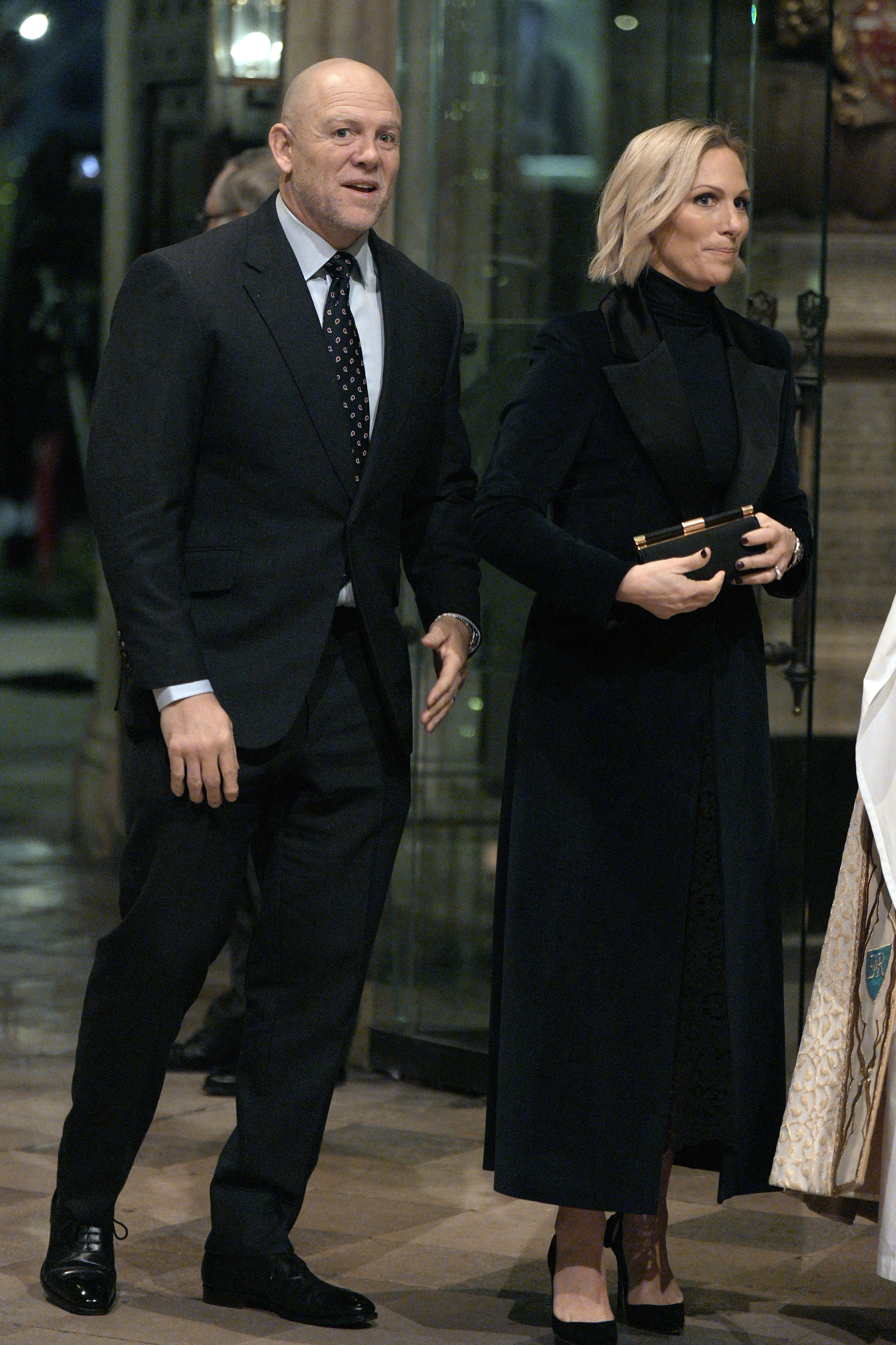 Zara Tindall and Mike Tindall walking into Westminster Abbey in black outfits