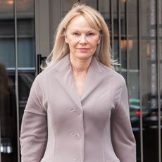 Pamela Anderson wearing a dusty mauve jacket with her hair down and no makeup.