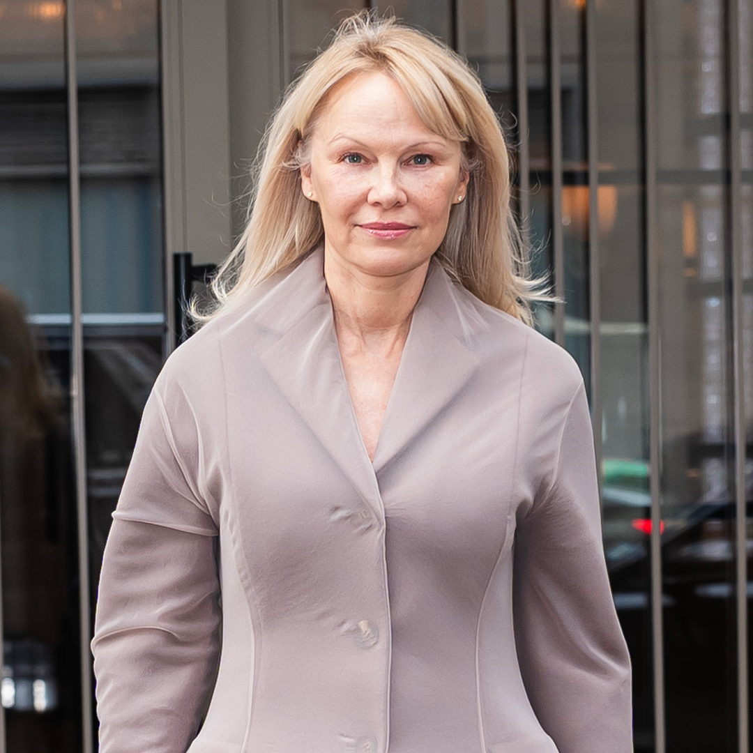 Pamela Anderson wearing a dusty mauve jacket with her hair down and no makeup. 