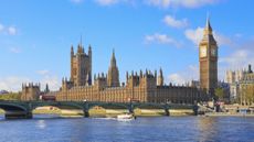 An image of the Houses of Parliament by the Thames on a sunny day
