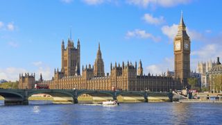 An image of the Houses of Parliament by the Thames on a sunny day