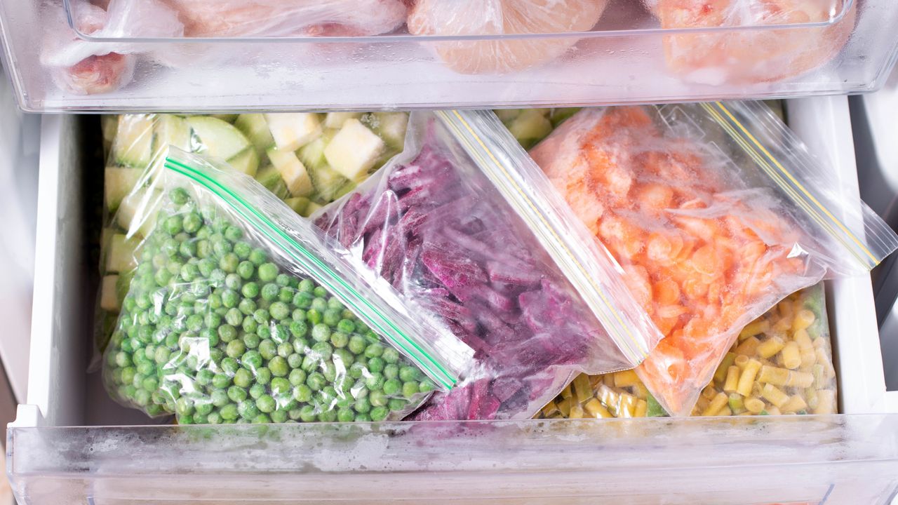 An image of an open freezer drawer that&#039;s got bags of neatly organized foods inside it