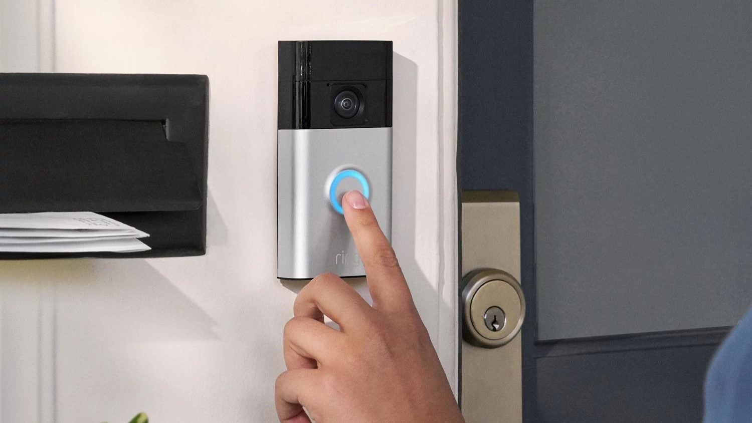 Person pressing the button on the Ring battery-operated doorbell