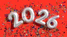 Silver balloons spell out 2026 against a red background and confetti.