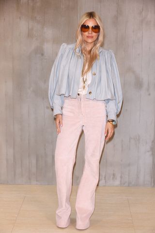 Sienna wears a cropped blouse, white top, pink corduroy pants, and oversize sunglasses.