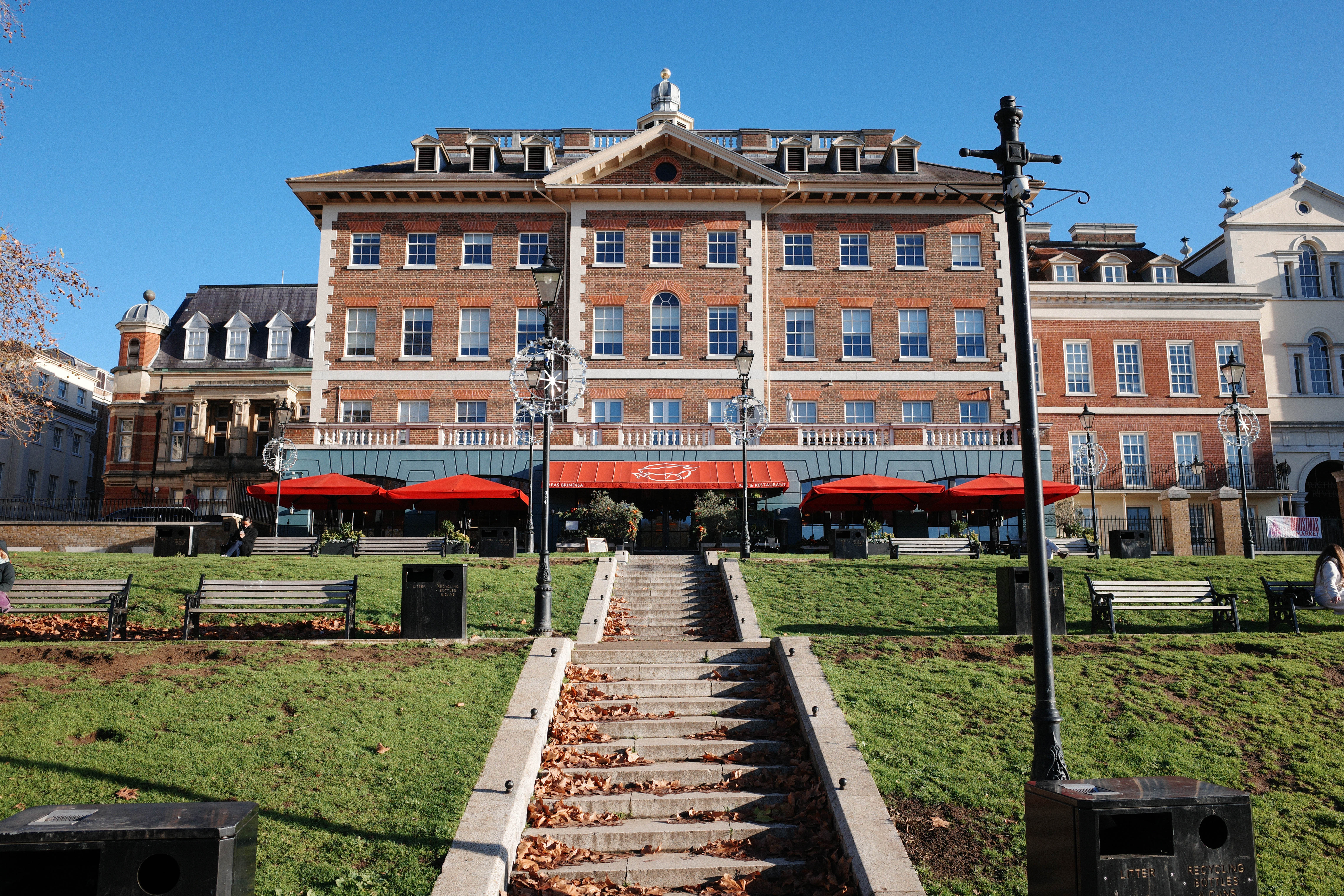 Stone steps leading up to a large building with colourful awnings
