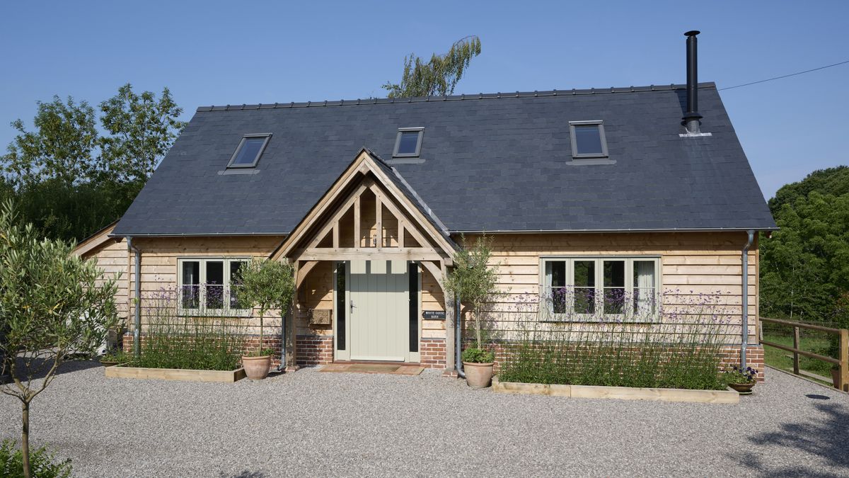 oak frame house with porch and grey front door