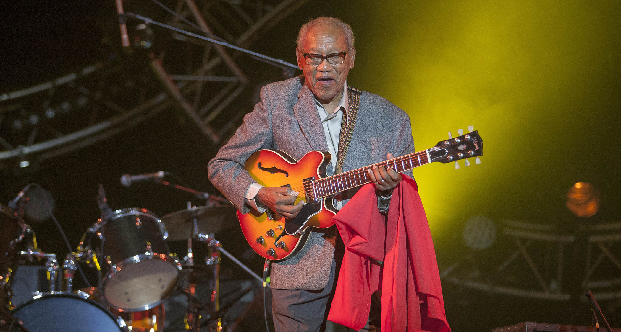 Ernest Ranglin performs in a gray suit with his trademark Gibson semi-hollow