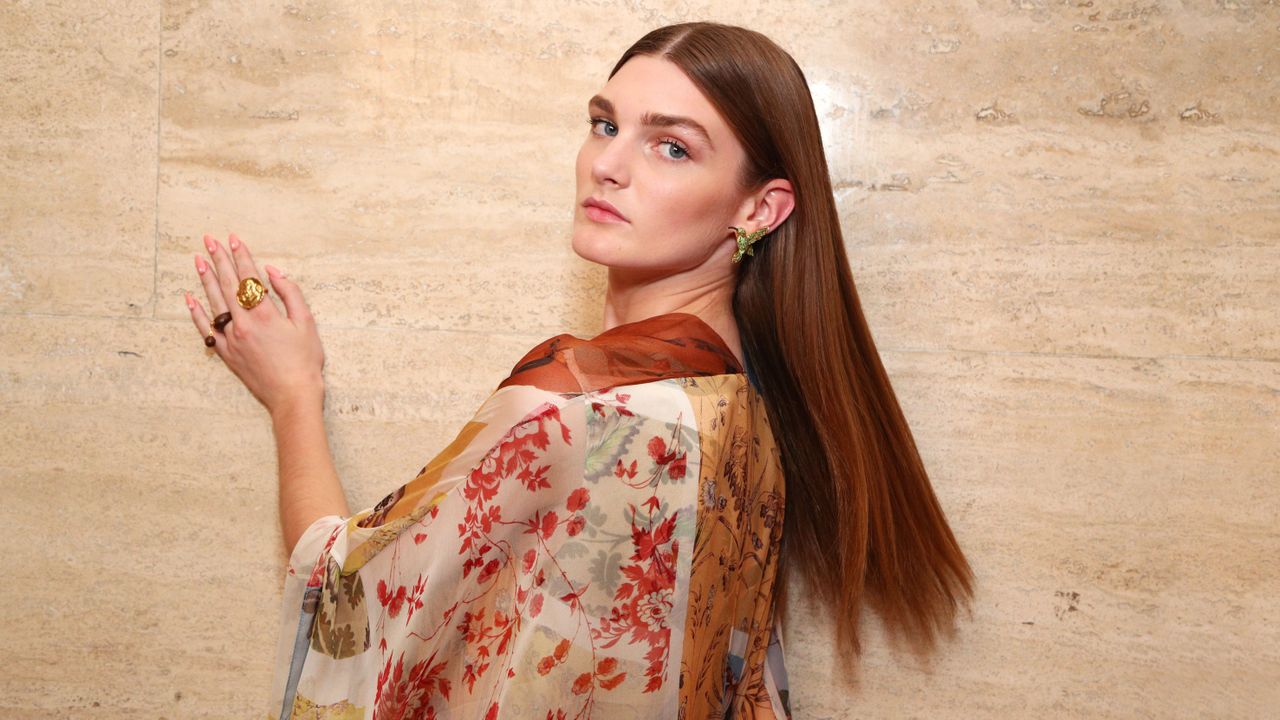 woman with long thick hair wearing a flowered shirt