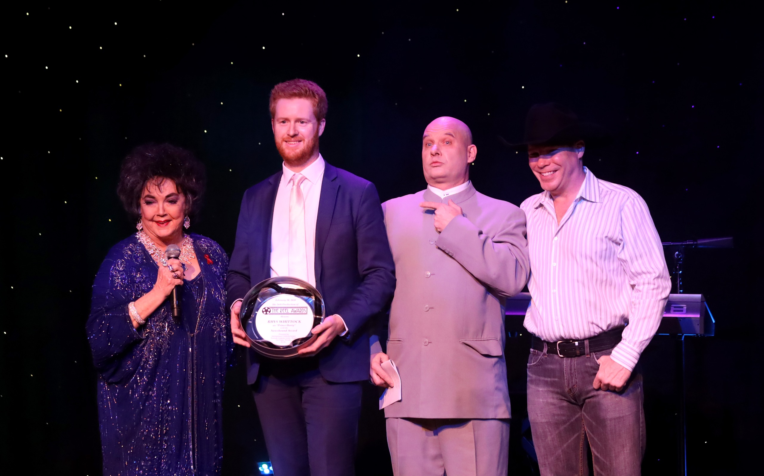 Celebrity impersonators standing on stage, including Prince Harry lookalike Rhys Whittock