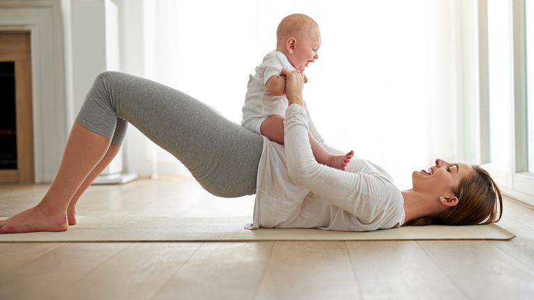 Mother exercising on the floor with her baby