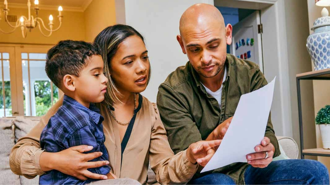 A family of three looking at a piece of paper