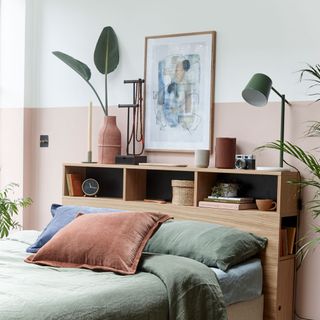 bedroom with painted wall panel and wooden shelves behind the bed