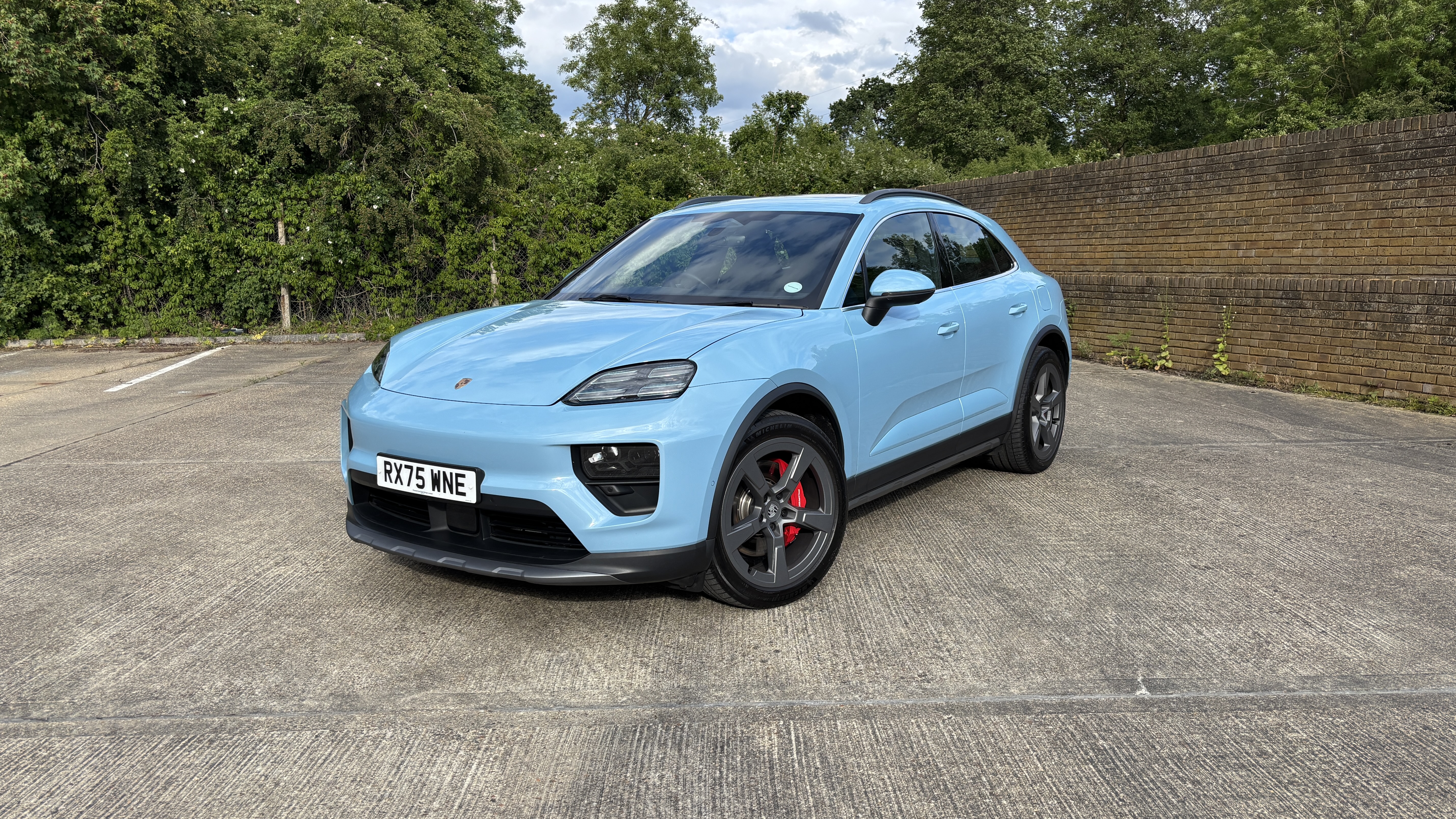 Porsche Macan electric in blue in a car park