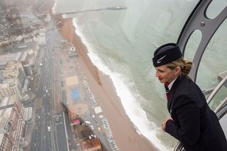 BRIGHTON, ENGLAND - AUGUST 02:A member of British Airways staff looks out of the i360 passenger pod during a press preview on August 2, 2016 in Brighton, England.The British Airways i360, des