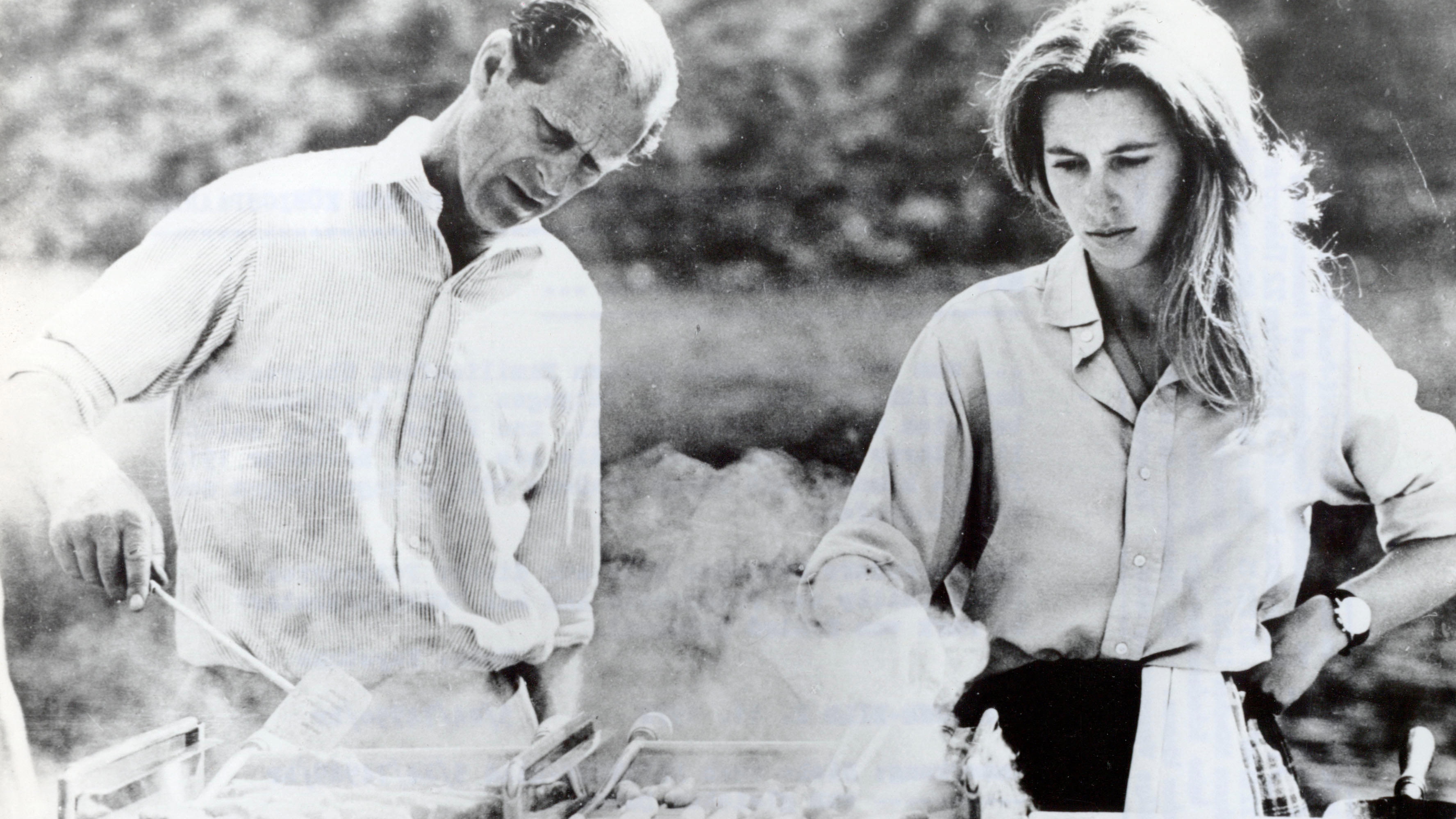 Prince Philip cooks food over a BBQ with Princess Anne
