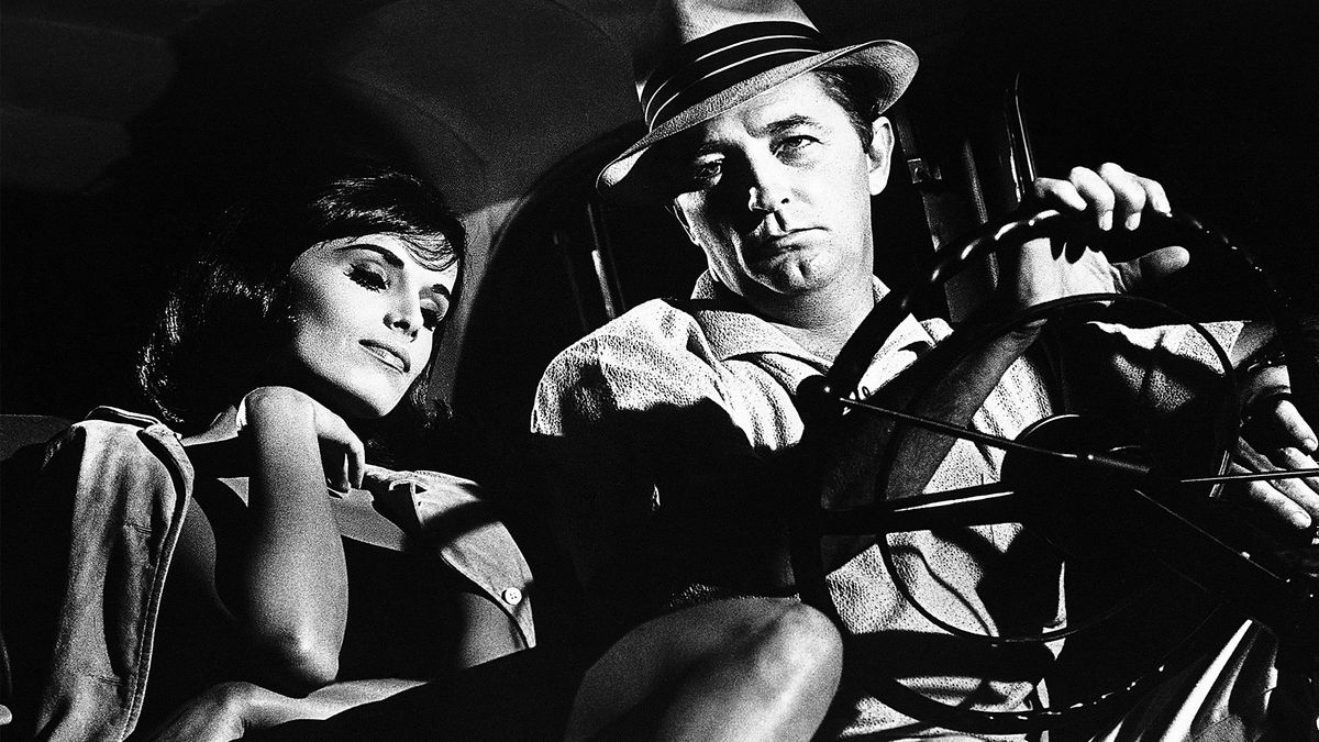 A black and white photo of a women sitting next to a man in a car 