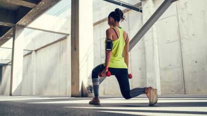 Woman performs a dumbbell lunge