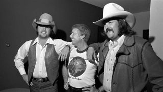 Marshall Tucker Band guitarist Toy Caldwell, Georgia Governor Jimmy Carter and Marshall Tucker Band guitarist George McCorkle are photographed during a pre-concert reception for the governor at the Stouffer's Hotel on October 31, 1975 in Atlanta, Georgia