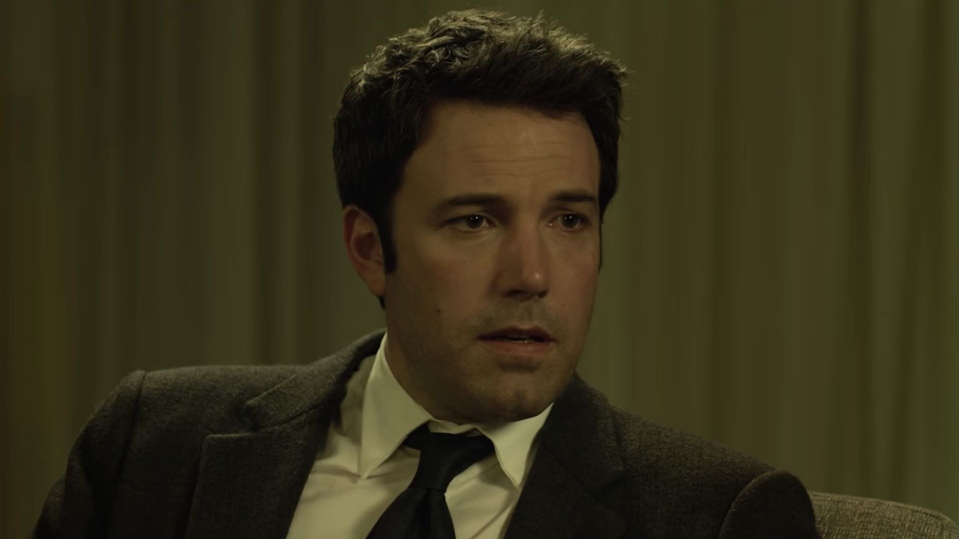Ben Affleck in a suit being interviewed during Gone Girl.