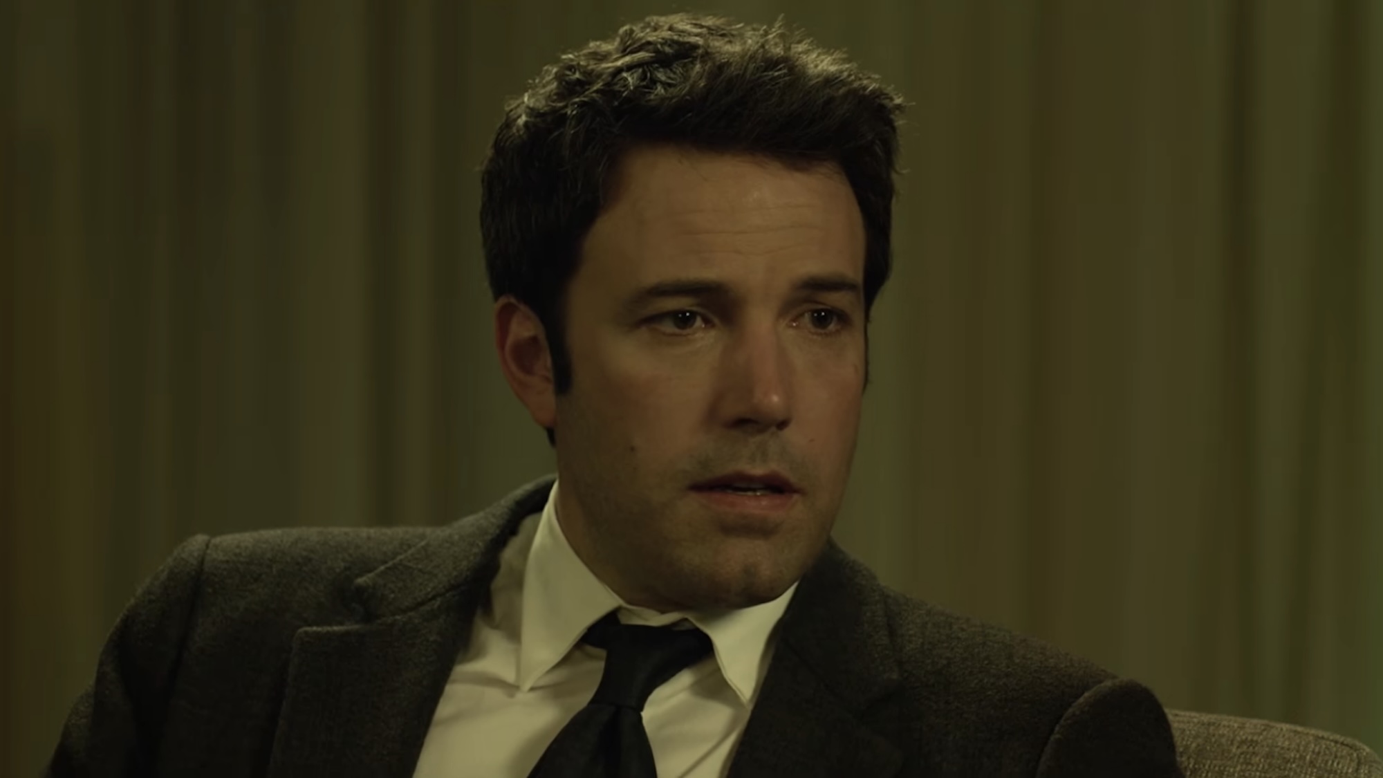 Ben Affleck in a suit being interviewed during Gone Girl.
