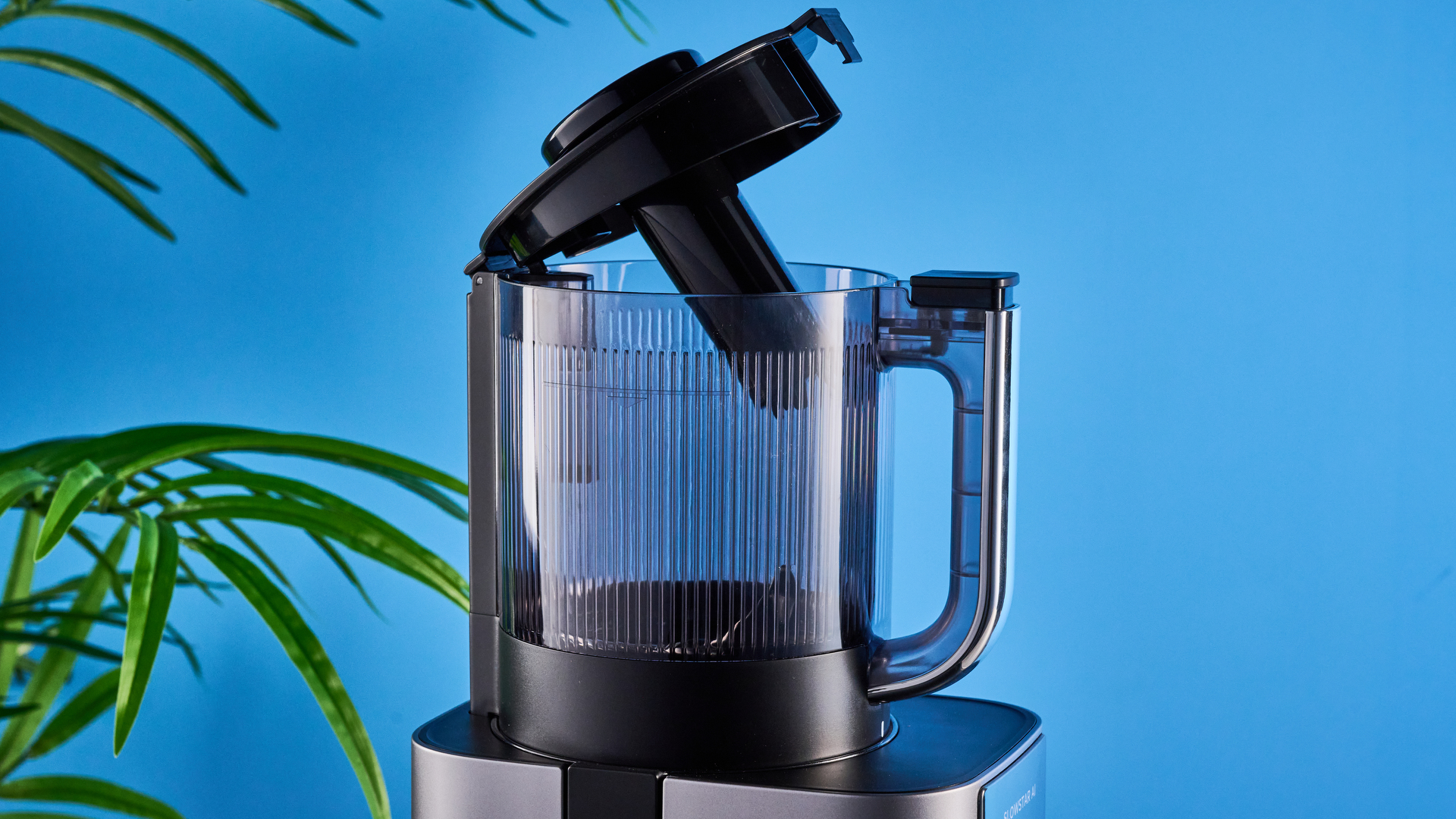 Tribest Slowstar AI Vertical Hopper Juicer photographed in front of a blue background