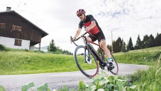 Man rides an electric road bike around a corner