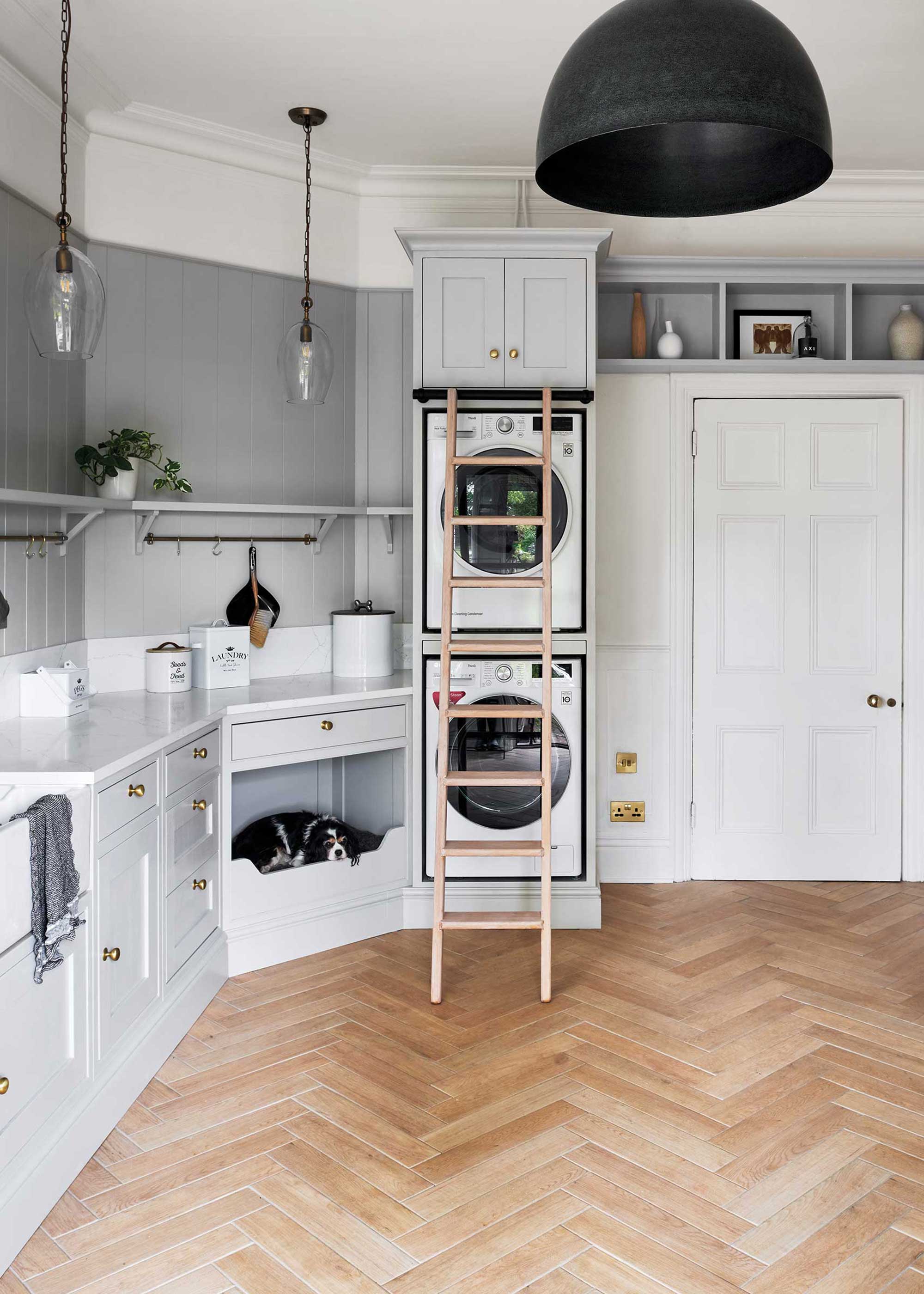 white laundry room with herringbone porcelain flooring and built-in dog bed