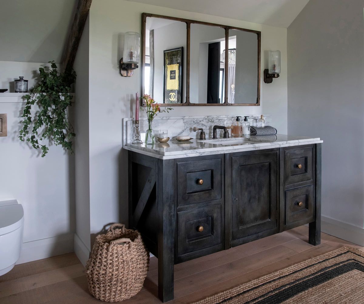 A bathroom with a wall toilet and a sink in the shape of a cupboard