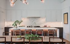 white kitchen with white top cabinets and wood lower cabinets, and white marble countertops