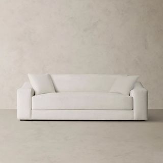 A white midcentury sofa on a beige background 
