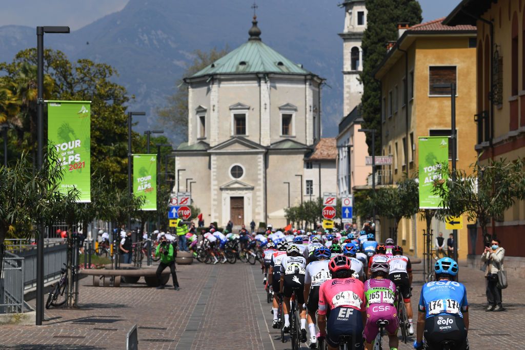 RIVA DEL GARDA ITALY APRIL 23 The Peloton passing through Riva del Garda Village during the 44th Tour of the Alps 2021 Stage 5 a 1209km stage from Valle del Chiese Idroland to Riva del Garda Church Landscape Fans Public TourofTheAlps TouroftheAlps on April 23 2021 in Riva del Garda Italy Photo by Tim de WaeleGetty Images