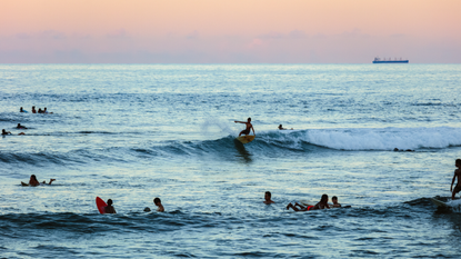 Surfers catch waves on the coastline of Siargao