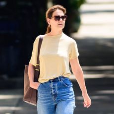 Katie Holmes wears a butter yellow t shirt with a madewell bag and jeans in new york city